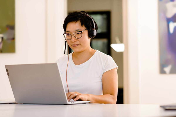 Frau mit Headset nimmt an einer Videokonferenz teil